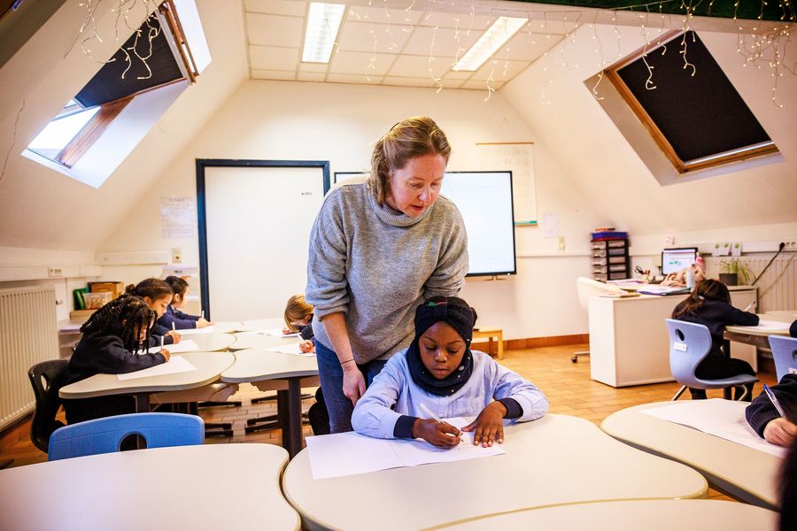 Leerkracht en leerling in de klas Leerkracht en leerling in de klas